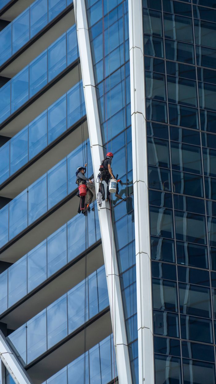 Professional window cleaners on skyscraper facade in Gold Coast, Australia.