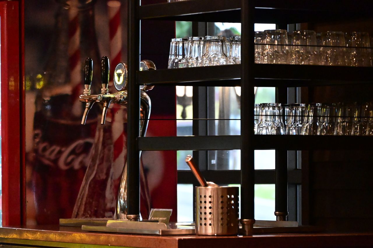 services-img Bar counter with drink dispensers and glassware in Johor Bahru, Malaysia, creating a warm, cozy atmosphere.